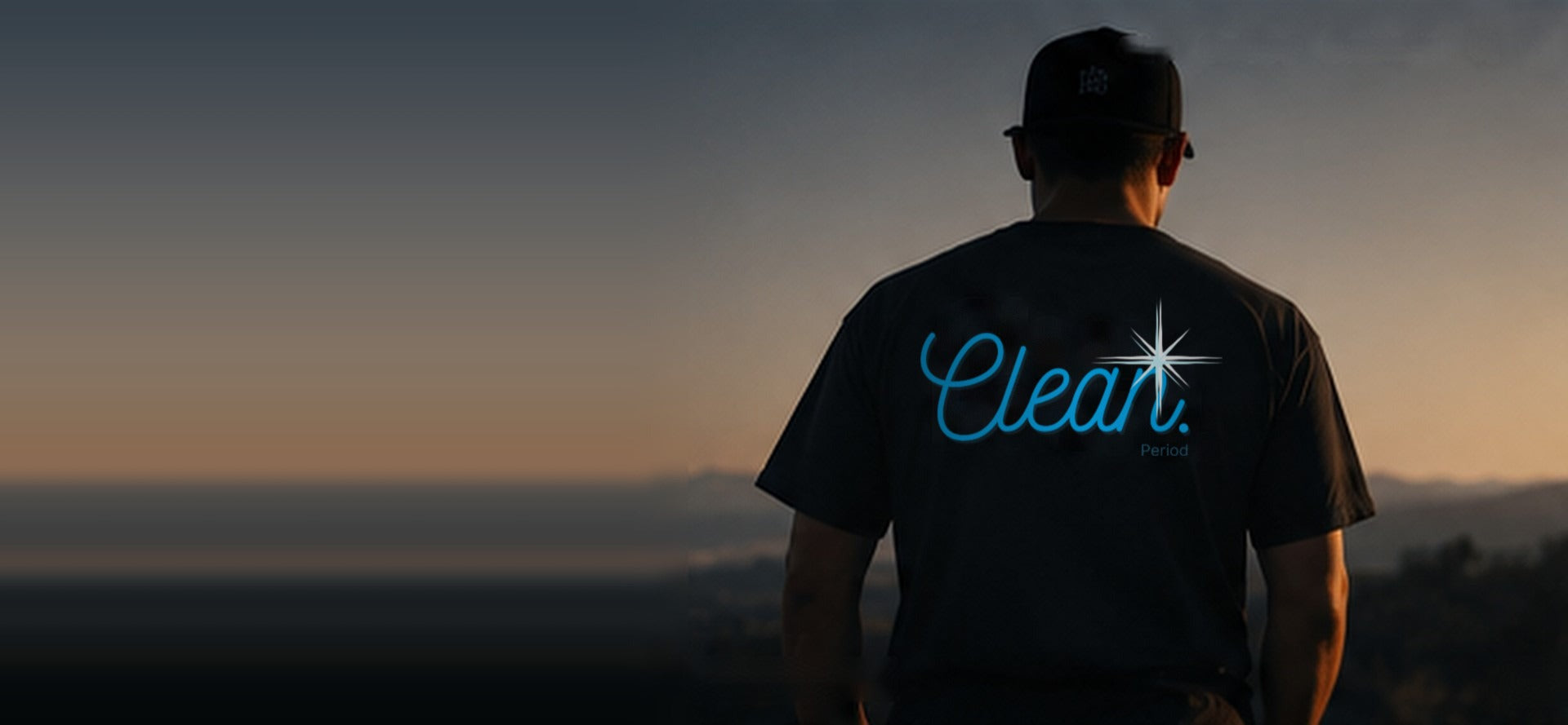 Man wearing a Clean. logo tee at sunset